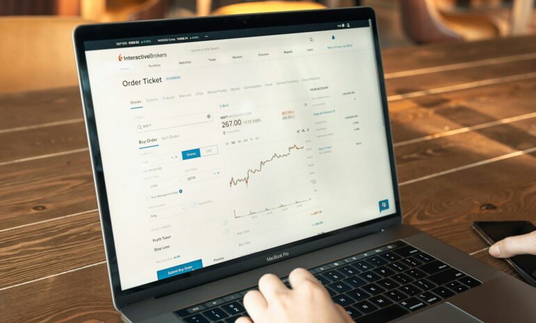 person using macbook pro on brown wooden table